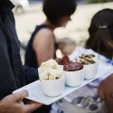 Servicemitarbeiter trägt eine Platte mit Brot, Antipasti und Oliven zu den Gästen im Restaurant Haberbüni