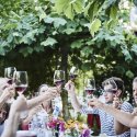 Gäste stossen mit Rotweingläsern im Garten des Restaurant Haberbüni an
