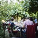 Gäste beim Essen an einem langen Tisch im grünen Garten des Restaurant Haberbüni