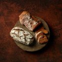 Verschiedene Brote und Brotscheiben auf einem Holzbrett im Restaurant Haberbüni
