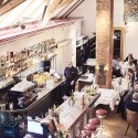 Innenraum des Restaurant Haberbüni mit Bar, gedeckten Tischen und Gästen