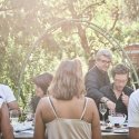 Gäste beim gemeinsamen Essen an einer langen Tafel im Garten des Restaurant Haberbüni